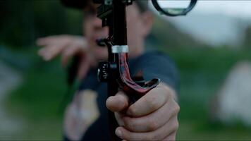 A young archer pulls on the bow string, taking aim at his target. photo