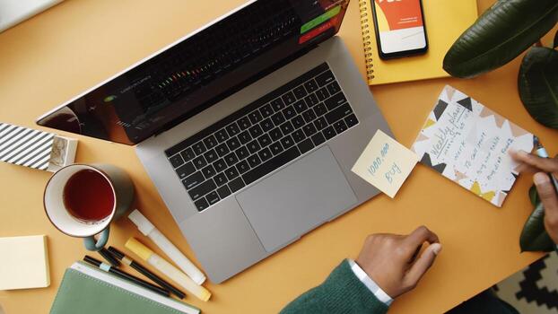 Top view of male trader analyzing stock market data while sitting at the office workstation with multiple computers photo