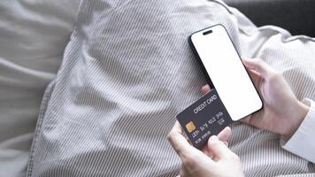 Close up female hands holding credit card and smartphone, young woman paying online, using banking service, entering information, shopping, ordering in internet store, doing secure payment photo