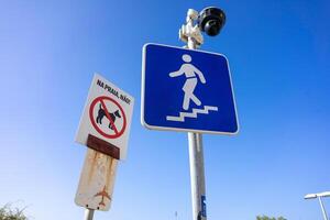 A CCTV camera at Praia da Rocha, Algarve, Portugal, monitors safety near a No Dogs Allowed sign, ensuring compliance and enhancing public security on this popular beach. photo
