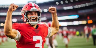 American football player in red uniform rejoices and raises his hands in fists up photo