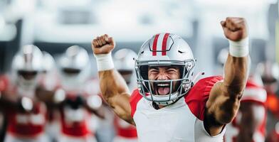 A joyful American football player in a red and white uniform cheers with his tongue out and his hands raised in fists photo