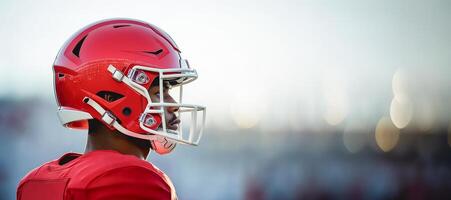 American football player in red uniform stands sideways photo