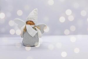 Christmas toy white angel on a white background with bokeh photo
