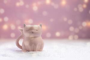 pink mug in the shape of a cat on a New Year pink background with bokeh photo