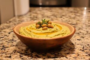 Creamy hummus with olive oil, paprika, and chickpeas in a rustic bowl on a warm kitchen countertop photo