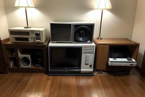 An assortment of classic 80's technology including VHS players, boomboxes, rotary phones, and early personal computers arranged in a nostalgic display with a retro color scheme photo