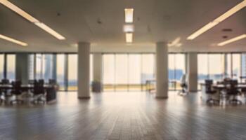 blurred open office space with large floor-to-ceiling windows, allowing plenty of natural light to flood the room. The soft focus creates a serene and modern ambiance, making it ideal for business photo