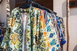 Uzbek dresses and female clothes made cotton with a colorful pattern at oriental bazaar in Uzbekistan photo