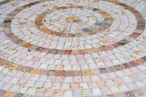 Ornate pebble pattern. The texture of the paving is made of gray cobblestones. photo
