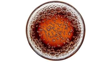 Top view of a glass of dark liquid with bubbles. photo
