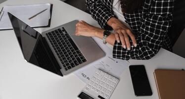 Office Worker Checking Time While Working Late at Night in a Modern Office Environment photo