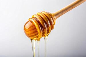 beehive, natural, golden, drizzle, organic, gourmet, A close up view of a golden drizzle of honey dripping from a dipped dipper onto a visually clean and minimalistic white background photo