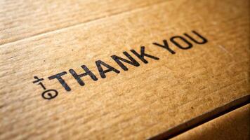 A close up shot of a cardboard box texture with the words Thank You written on it captured from a worm s eye view against a plain white background, gratitude, material, handwritten photo