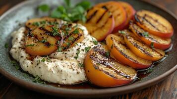 Grilled peaches on creamy cheese with herbs and balsamic drizzle. photo