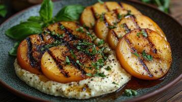 Grilled peaches served on a creamy base with herbs. photo