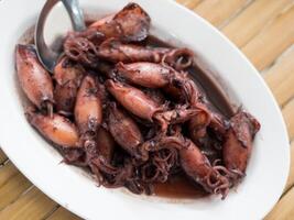 Sauteed black squid is processed squid that is cooked until the squid ink is released. The resulting taste is very distinctive. photo
