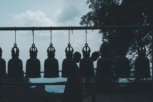 Old bell hangs on steel rail in The stone with the footprint of Lord Buddha at Khitchakut mountain. photo