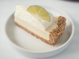 Slice of cheesecake with lemon filling decorated with lemon slice. photo