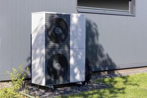 Heat pump unit installed outside a modern building photo