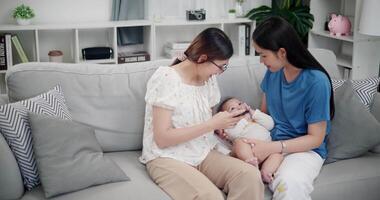 Handheld high angle view shot, Happy family having fun with little son on sofa in the living room, enjoying fun time together. Multi-generation family video