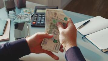 Counting cash in an office setting with various currencies, including rubles and dollars during work hours video