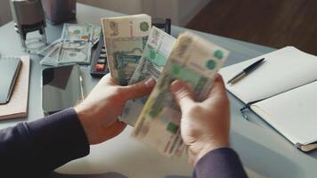 Counting cash and handling currency at a desk in a modern office setting on a weekday afternoon video