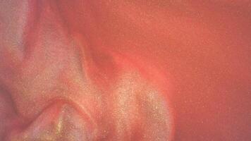Abstract blurred shiny background with sequins. mother-of-pearl water is the color of the year Peach fuzz. Liquid with a metallic sheen, the movement of water. Bath salts video