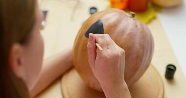 Woman Painting Face on Pumpkin for Halloween video