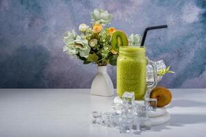 Kiwi Smoothie with Ice and Floral Arrangement photo