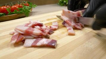Cured bacon cutting with a knife on a cutting board. video