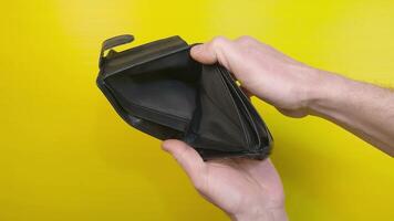 Empty billfold. Person opens black leather wallet without money, view from top video