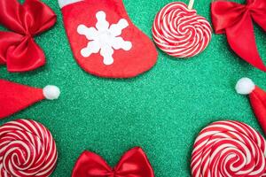 Flatlay of some red Christmas decoration, on a green background. Background for Christmas. photo