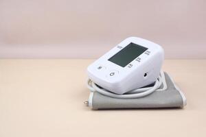 Digital blood pressure tonometer and pack of pills on a light background with copy space. photo
