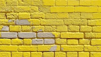 The texture of the brick wall of many rows of bricks painted in yellow color. photo