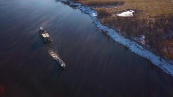 industrial fundo com uma barcaça e uma rio com Nevado costa. grampo. carga navio transportando bens em uma campo fundo. video