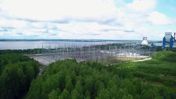 Bird's-eye view. Clip.Green forest around the river with plants around and pipes and white clouds around. video