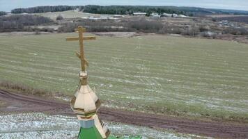 Top view of church cross on background of village fields. Clip. Village church with cross on top of golden domes. Rustic landscape with fields and church in late autumn video