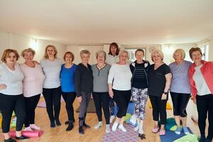 A vibrant community of senior women, guided by their instructor, embraces the enriching journey of yoga, fostering unity, well-being, and a shared commitment to active aging photo