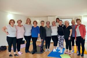 A vibrant community of senior women, guided by their instructor, embraces the enriching journey of yoga, fostering unity, well-being, and a shared commitment to active aging photo