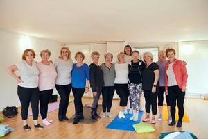 A vibrant community of senior women, guided by their instructor, embraces the enriching journey of yoga, fostering unity, well-being, and a shared commitment to active aging photo