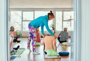 Experienced yoga instructor demonstrating safe and effective exercises for seniors to improve flexibility and balance. photo