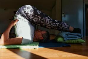 Senior Woman Practicing Back Stretches in a Sunlit Space for Optimal Health and Well Being photo