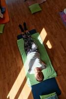Senior woman practicing stretching and meditation on the floor, focusing on proper alignment and relaxation. photo