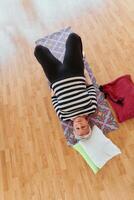 Senior woman practicing stretching and meditation on the floor, focusing on proper alignment and relaxation. photo