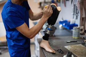 Technician crafting a prosthetic leg in workshop setting photo