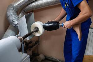 Technician polishing a prosthetic leg in workshop setting photo
