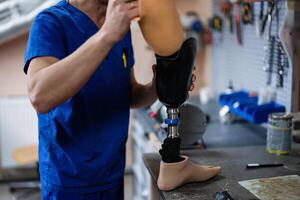 Technician assembling prosthetic leg in workshop setting photo