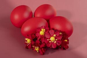 Colorful eggs, symbolizing Easter, on a colorful background and flowers photo