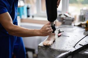 Technician adjusting a prosthetic leg in a workshop setting photo